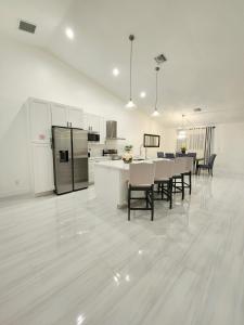 a kitchen and dining room with white cabinets and a table and chairs at Zone T & A Escape in Fort Lauderdale