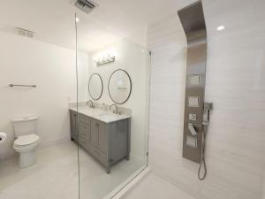 a bathroom with a toilet and a sink and mirror at Zone T & A Escape in Fort Lauderdale +45 photos