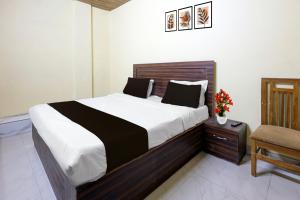 a bedroom with a large bed and a chair at Hotel O Uttaranchal University Dehradun in Jhājra +19 photos