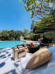 a patio with pillows next to a swimming pool at The Hideaway Hosur by evaddo stays in Hosūr