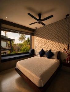 a bedroom with a large bed with a ceiling fan at Islaya Siargao on Opening Phase in General Luna
