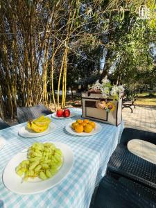 a table with plates of fruits and vegetables on it at The Hideaway Hosur by evaddo stays in Hosūr