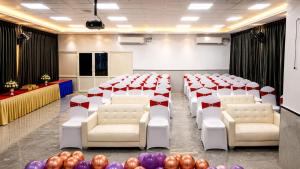 a room with white chairs and red and white dividers at Hotel Takasi Heaven in Anakāpalle