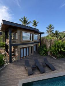 a house with a deck next to a swimming pool at Islaya Siargao on Opening Phase in General Luna