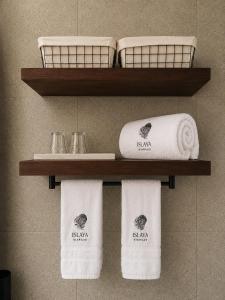 four towels on a shelf in a bathroom at Islaya Siargao on Opening Phase in General Luna