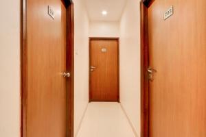 a hallway with two wooden doors and a tile floor at Townhouse Oak Ramdaspeth Downtown in Nagpur