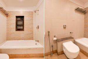 a bathroom with a tub and a toilet and a sink at Townhouse Oak Ramdaspeth Downtown in Nagpur
