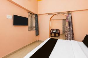 a bedroom with a bed and a tv on the wall at Hotel O AIIMS Raipur in Raipur +24 photos