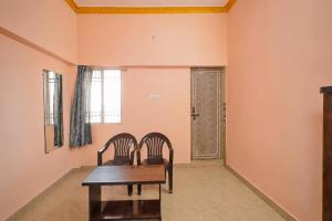 a dining room with two chairs and a table at Hotel O AIIMS Raipur in Raipur