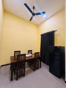 a dining room with a table and a ceiling fan at nama villa in Arugam Bay