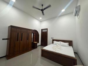 a bedroom with a bed and a ceiling fan at nama villa in Arugam Bay +1 photo