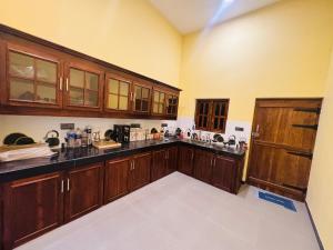 a large kitchen with wooden cabinets in a room at nama villa in Arugam Bay