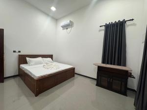 a bedroom with a bed and a chair in it at nama villa in Arugam Bay