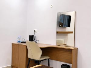 a desk with a chair and a mirror at Hotel Takasi Heaven in Anakāpalle +4 photos