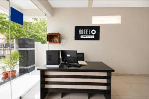 an office with a desk with a laptop computer on it at Super Hotel O Temple Road Vemulavada in Karīmnagar