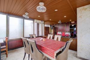 a dining room with a red table and chairs at Collection O Downtown Hospital Guwahati Formerly Cherry City Cottage in Guwahati