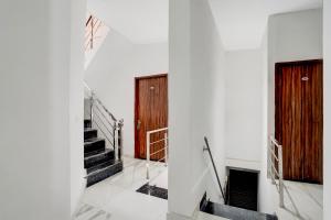 a hallway with stairs and a wooden door at Super Hotel O by OYO ISBT Mohali Formerly Holiday Spot in Mohali