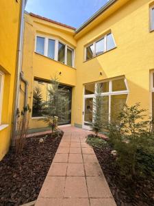 a yellow house with a walkway in front of it at Hedera Home in Komárno