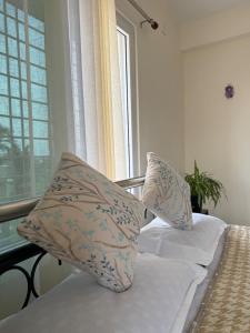 a bed with two pillows on it with a window at Retreat Homes in Siliguri
