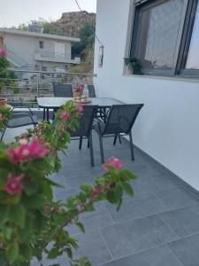 a patio with a table and chairs and flowers at Dani & Fani suite in Afantou +8 photos