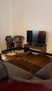 a living room with a table and a tv at Rest Harrow Estate in Kandy +13 photos