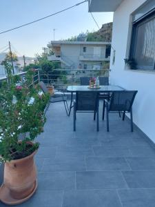 a patio with a table and chairs on a balcony at Dani & Fani suite in Afantou