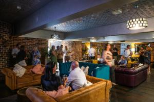 a group of people sitting on couches in a room at Rydges Armidale in Armidale