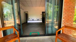 a glass door leading into a room with a bed at Elevara Eco Resort - Wasgamuwa in Kathurupitiya
