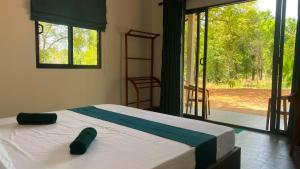 a bedroom with a bed and a large window at Elevara Eco Resort - Wasgamuwa in Kathurupitiya