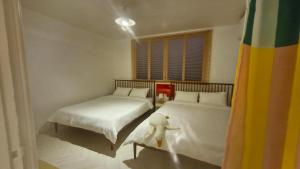 a bedroom with two beds and a window at 케이앞산 하우스 in Daegu