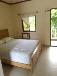 a bedroom with a large bed and a window at Gemini Hotel & Restaurant in Libaong