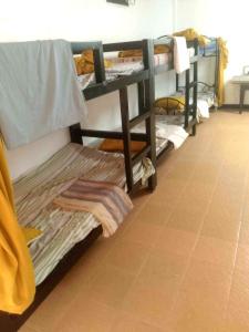 a room with two bunk beds and a tile floor at Gemini Hotel & Restaurant in Libaong