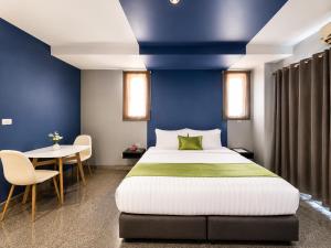 a bedroom with a large bed and a table at iCheck inn Phuket Town in Phuket