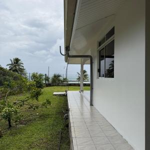 a porch of a house with a view of the ocean at Fare Havai - Raiatea in Taputapuapea