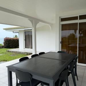 a ping pong table on a patio with chairs at Fare Havai - Raiatea in Taputapuapea