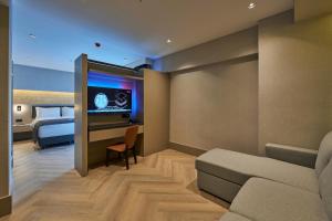 a room with a bed and a couch and a desk at Ramses Hotel İzmir in İzmir