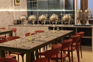 a long table with chairs and wine glasses on it at Grand Heritage in Ernakulam