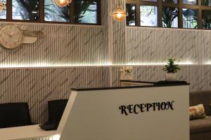 a reception desk in a room with a clock at Grand Heritage in Ernakulam