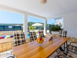 a dining room with a table with a bowl of fruit on it at Vacation home Marin in Vinišće
