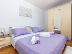 a bedroom with two beds with purple pillows at Vacation home Marin in Vinišće