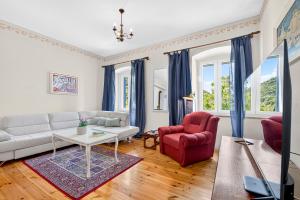 a living room with a white couch and a red chair at VILLA Mara in Dubravka
