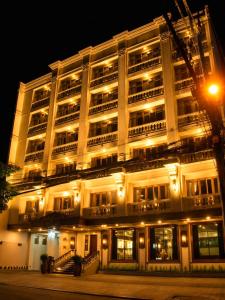 a large white building with lights at night at Herald Suites Polaris in Manila