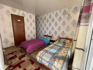 ein Zimmer mit zwei Betten in einem Zimmer mit einer Tür in der Unterkunft Baisuu in Bosteri