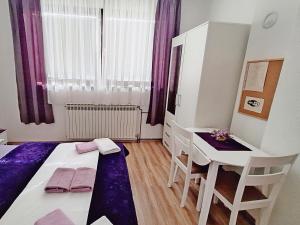 a bedroom with a bed and a desk and a table at Apartment Rendulic in Rakovica