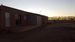 a building with a deck with the sunset in the background at Lara Lodge in Lara