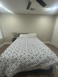 a bedroom with a bed with a black and white comforter at Only minutes away from Surfside Beach in Freeport