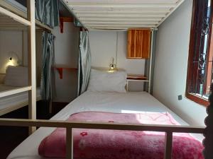 a small room with a bunk bed and a window at City Backpackers Hostel in Luang Prabang