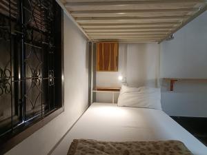 a small room with a bed and a window at City Backpackers Hostel in Luang Prabang
