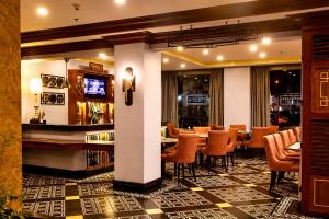 a restaurant with a bar and tables and chairs at Herald Suites Polaris in Manila