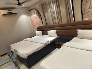 a room with two beds and a chair in it at Hotel Radhika in Lātūr +15 photos